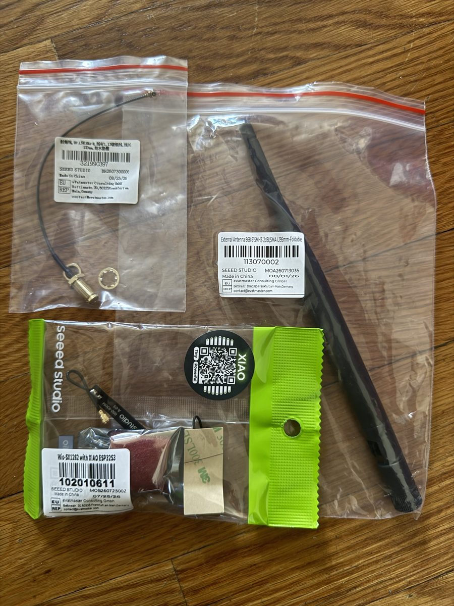 The XIAO ESP32-S3 and Wio-SX1262 kit, a 2 dBi folding antenna and an SMA bulkhead cable in their delivery bags